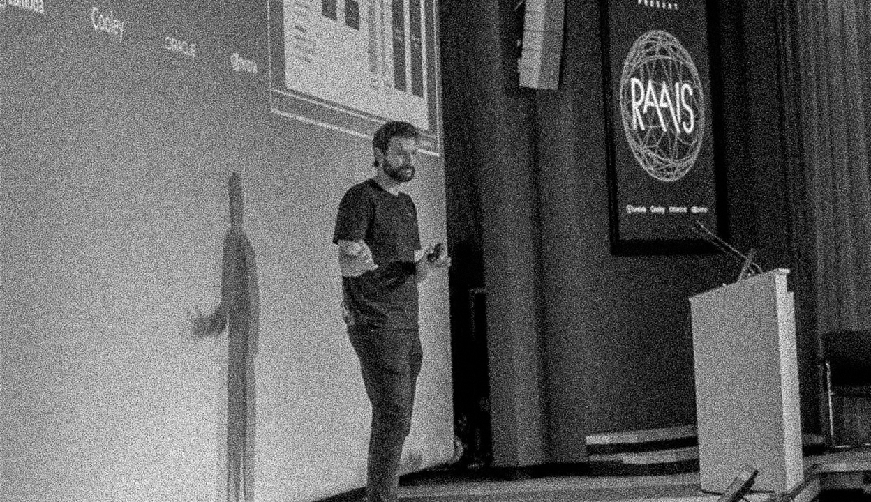 Eiso speaking onstage at RAAIS 2025.